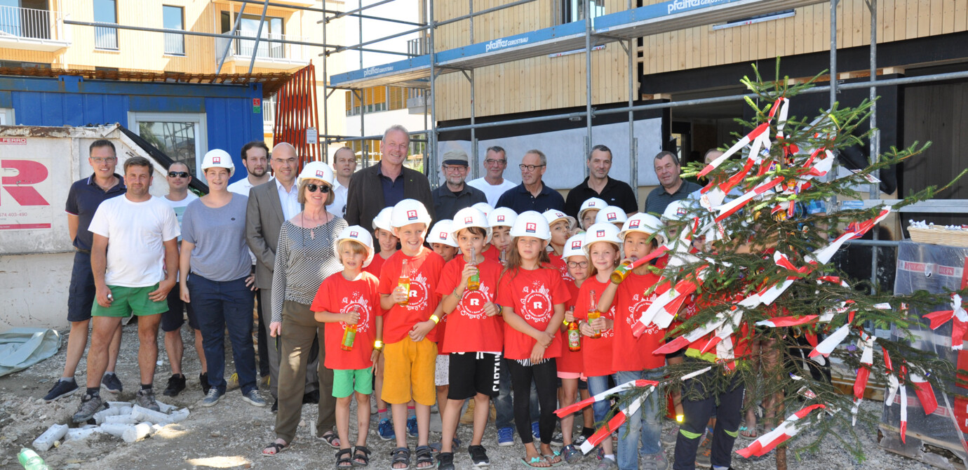 Bauherr, Generalunternehmer, Architekten und Handwerker feierten gemeinsam mit Kindern der benachbarten Volksschule die Dachgleiche des Holzbauprojekts „Blattur“ in Götzis.
